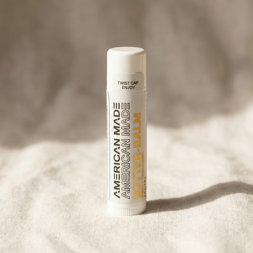 Lip balm with 'American Made' text on a textured beige background